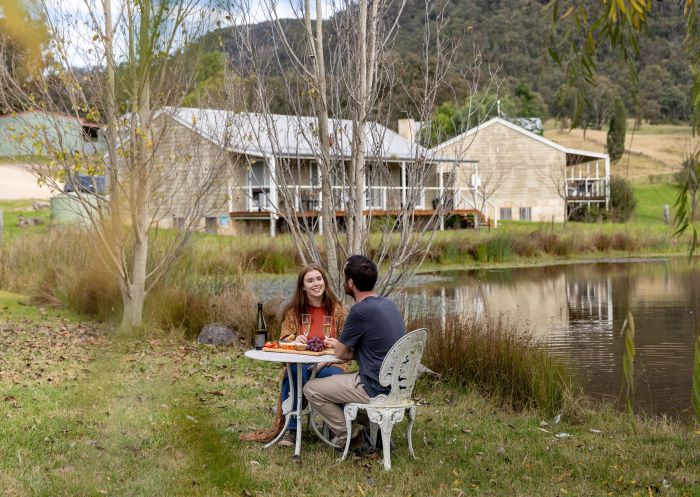 Starline Alpaca Farmstay, Hunter Valley Couple enjoying food and wine outdoors at Starline Alpaca Farmstay, Hunter Valley