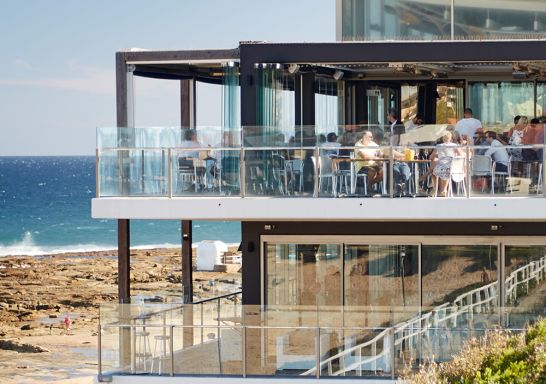 紐卡素（Newcastle）Merewether Surfhouse 的人們一邊欣賞海景，一邊享用美食和飲品