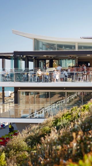 人們在紐卡素（Newcastle）的Merewether Surfhouse 一邊欣賞海景一邊享用美食和飲品